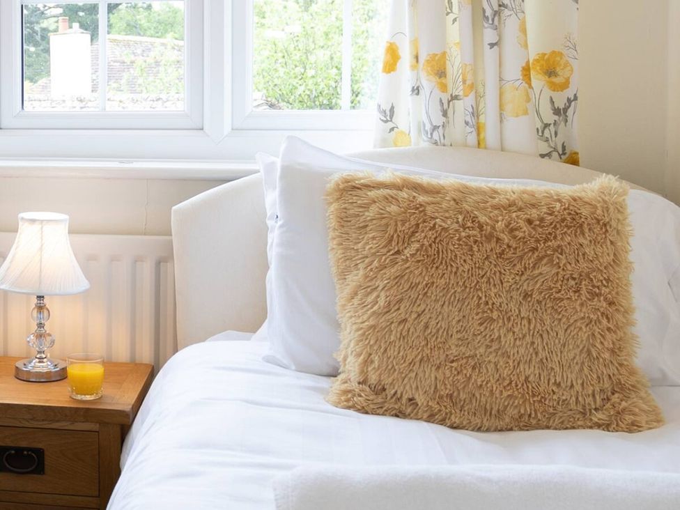 A bed with a pillow and lamp in a bedroom