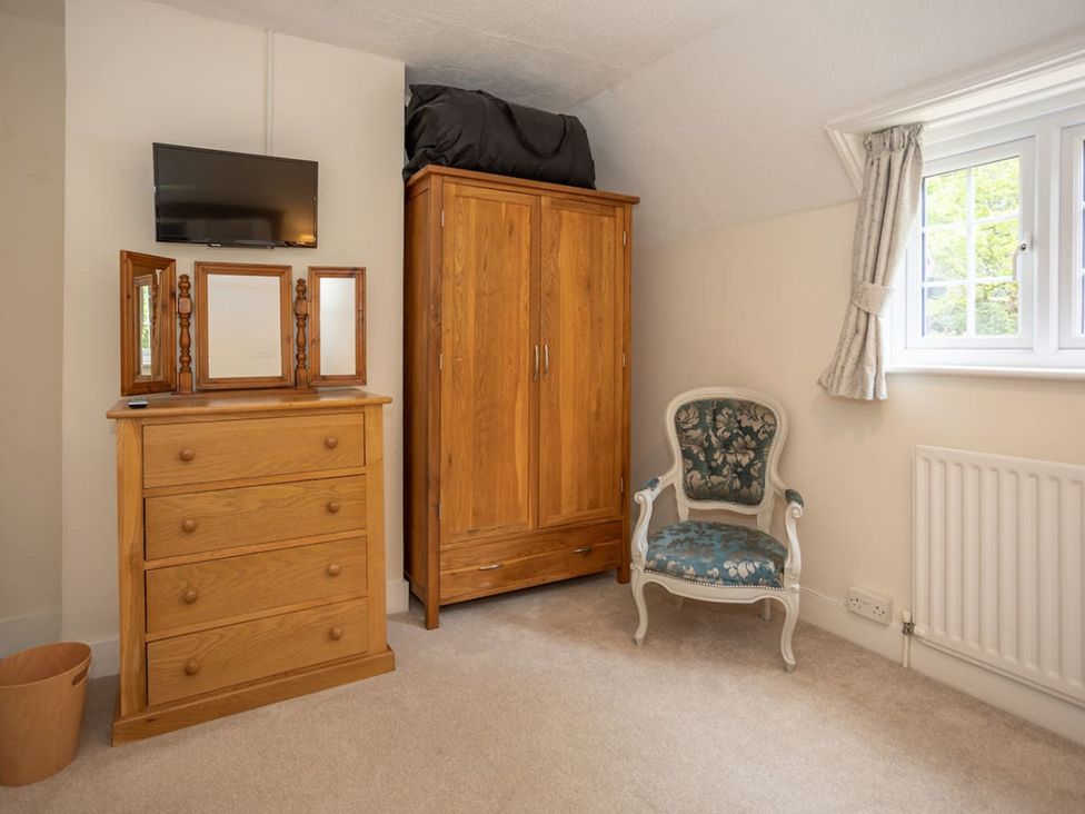 A bedroom with a wardrobe and a chair at The Old Barn in Manchester