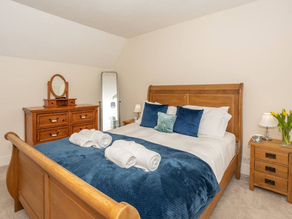 A bedroom with a bed and dresser at a property