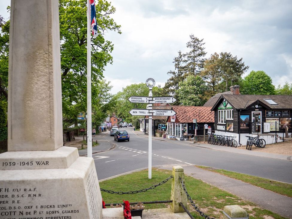 An outdoor scene with a monument and signpost at a village crossroad