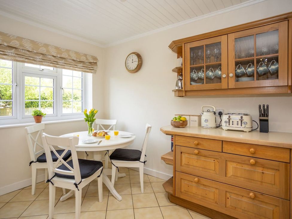 A kitchen with a table and chairs along with cabinetry at The Old Barn in Manchester