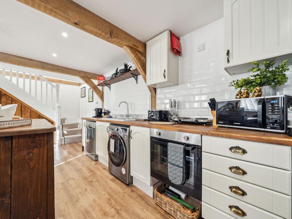 A kitchen with appliances and wooden cabinets at The Old Barn in Manchester