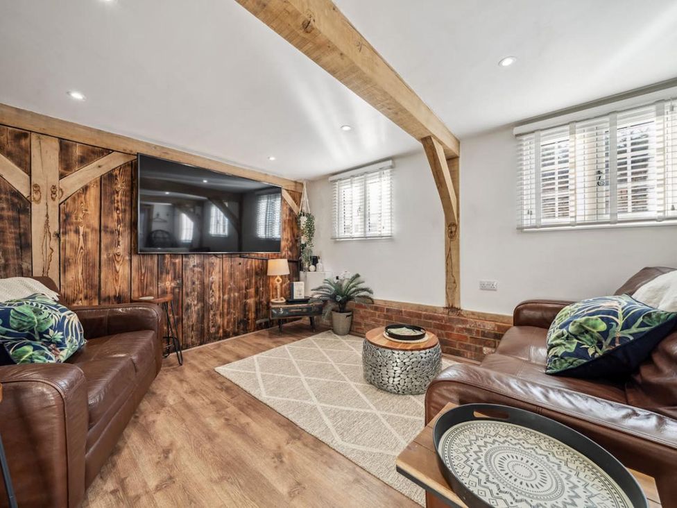 A living room with a television and sofas at The Old Barn in Manchester