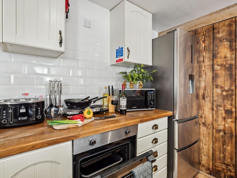 A kitchen with a stove, fridge, and countertop items at 