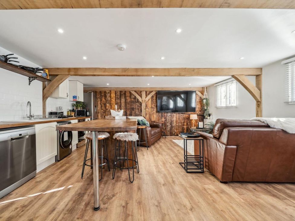 A living room with kitchen appliances and seating area at the property