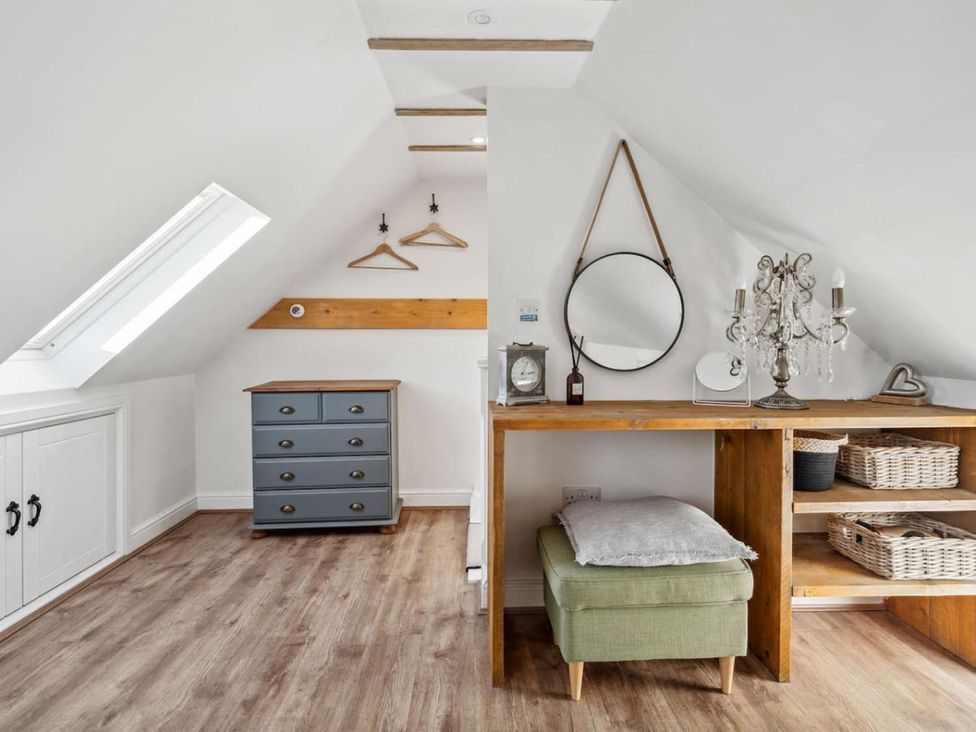 An attic room with a dresser and a wooden table at 