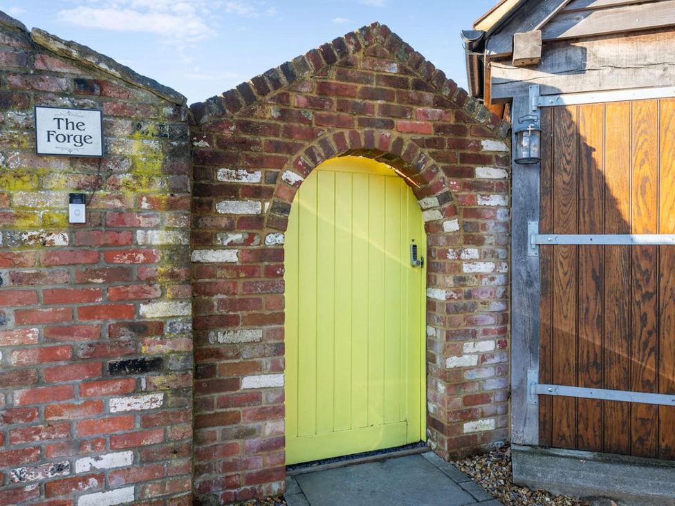 A yellow door and brick wall at The Forge in an outdoor area