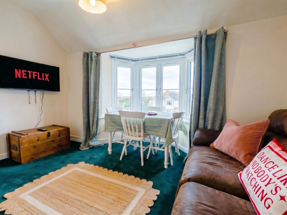 A living room with a television and dining table at The Old Barn in Manchester