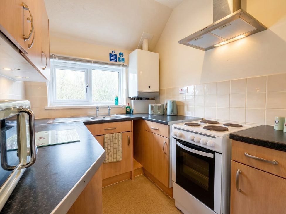 A kitchen with a stove, sink and cabinets at the property in unspecified location
