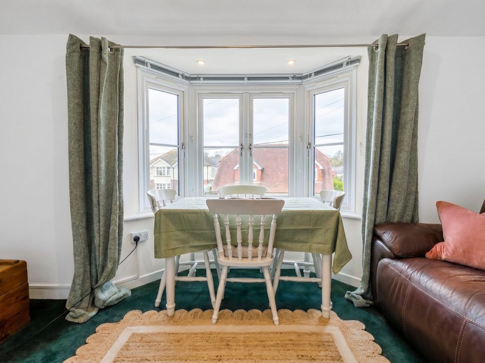 A dining room with a table and chairs near a window at the property