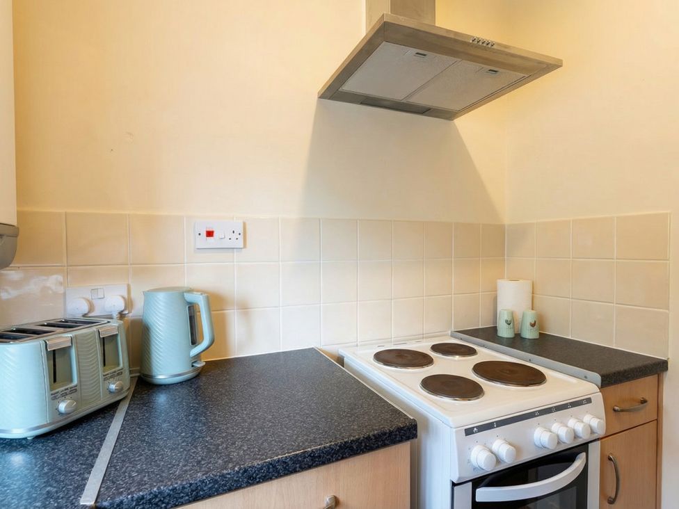A kitchen with kettle and toaster on the counter at 