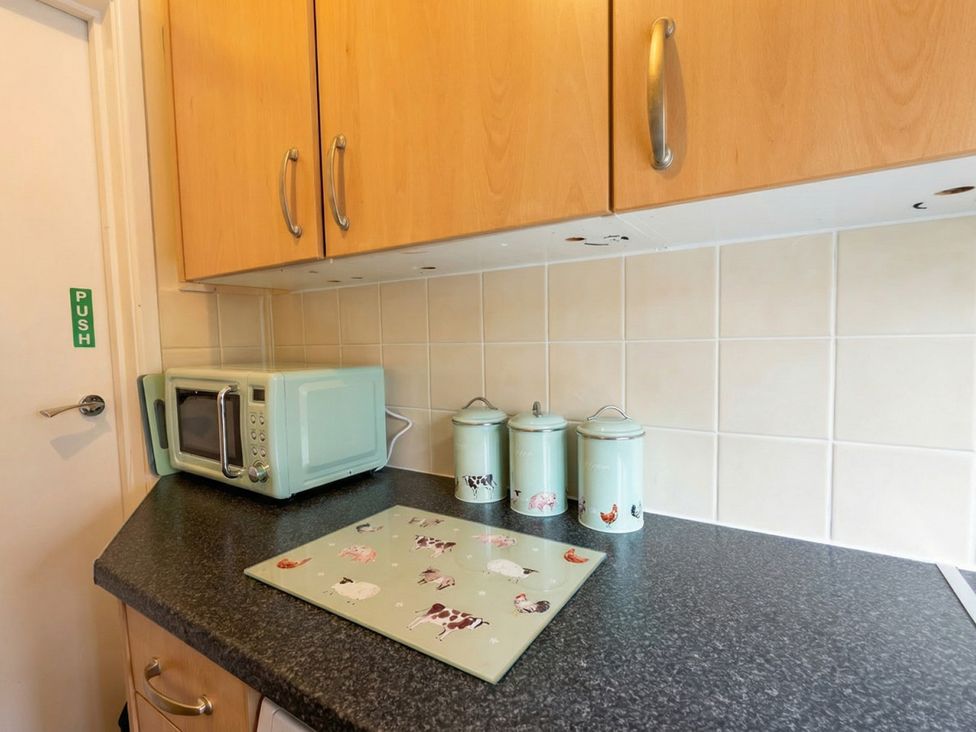 A kitchen with cabinets and appliances at The Old Barn in Manchester