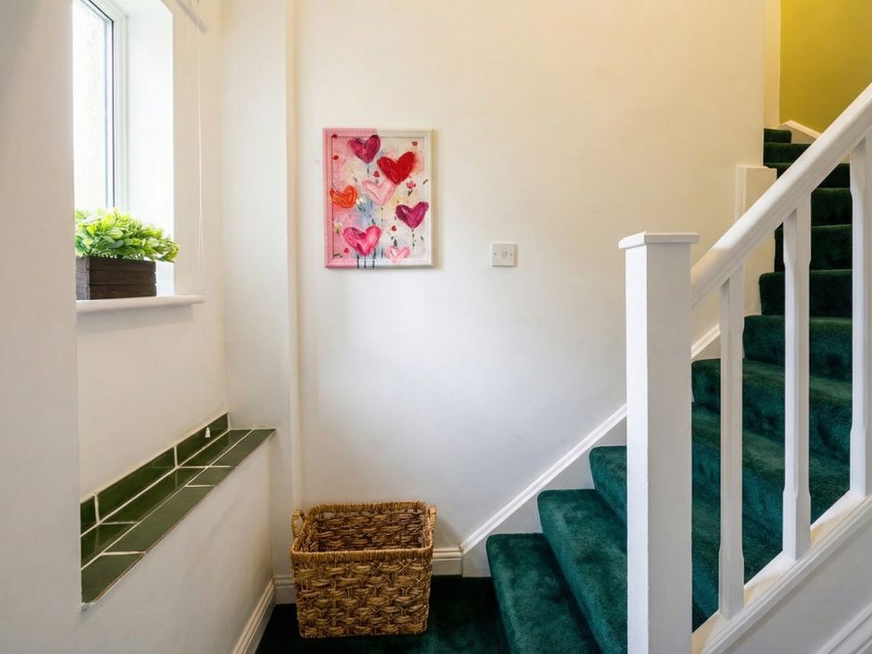A hallway with a staircase and a window at The Old Barn in Manchester