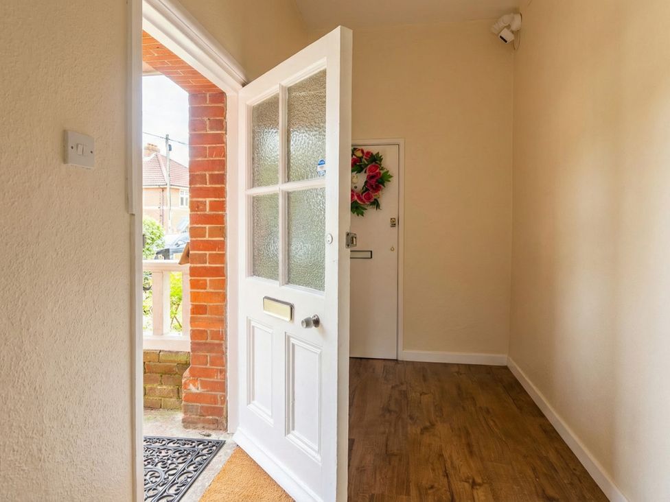A hallway with a door and a decorative wreath at 