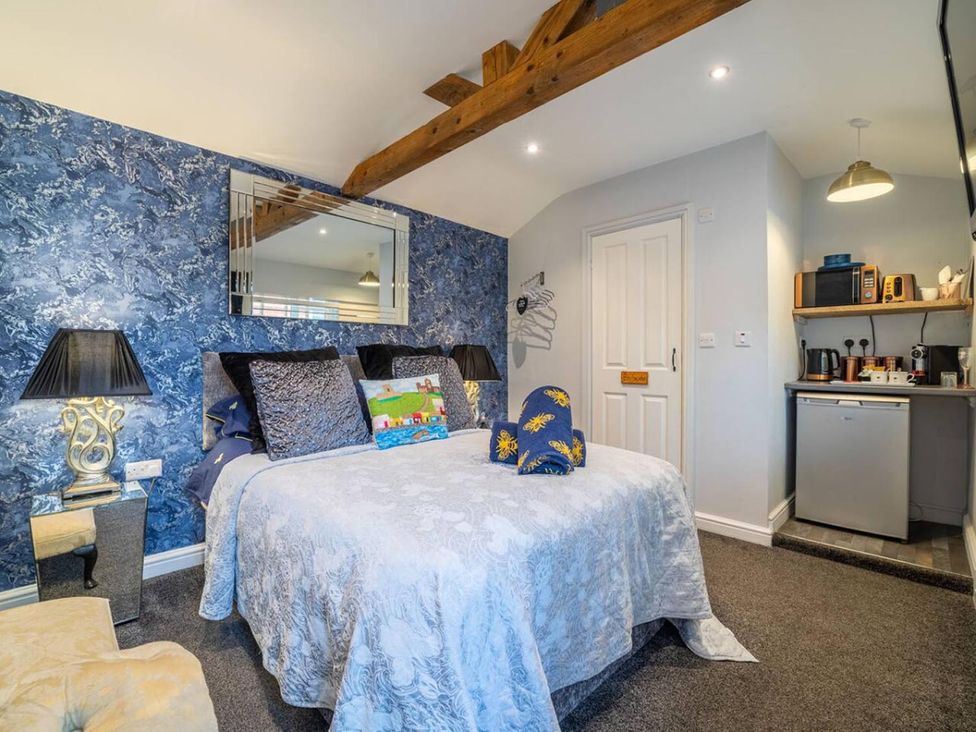 A bedroom with a bed and kitchenette at The Old Barn in Manchester