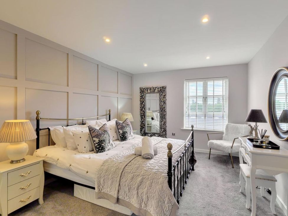 A bedroom with a bed and mirror at The Old Barn in Manchester