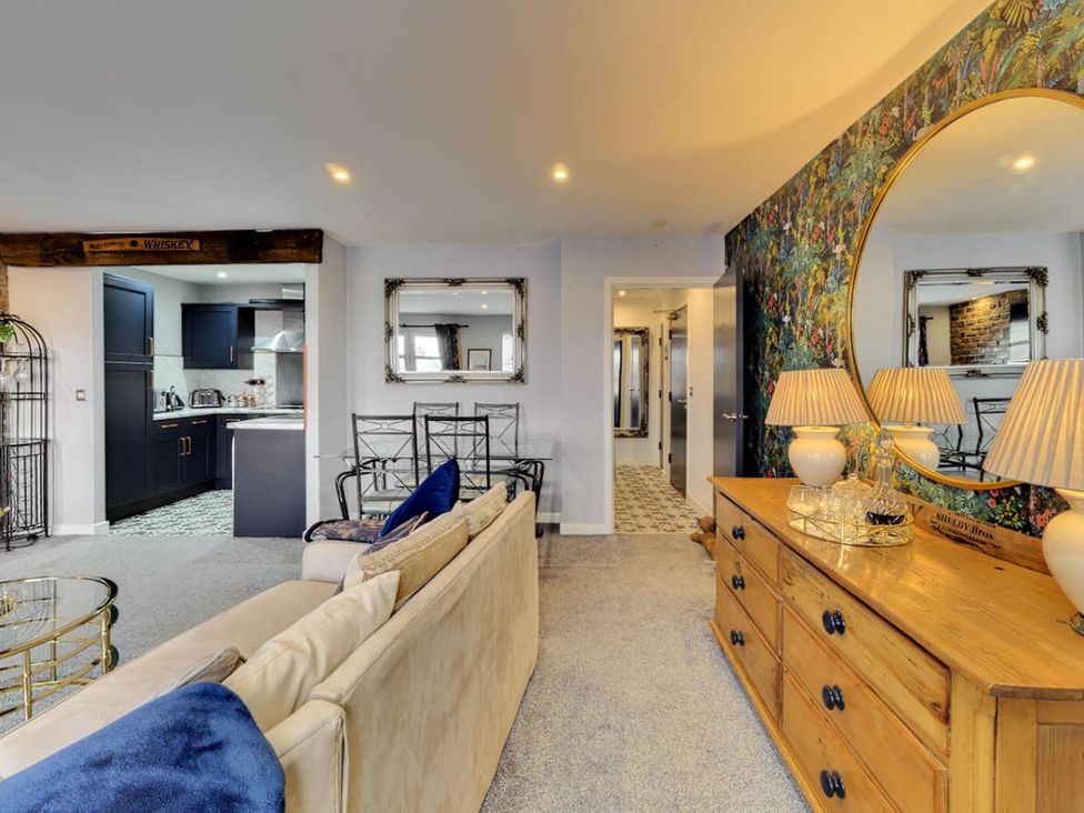 A living room with a sofa and dining area at The Old Barn in Manchester