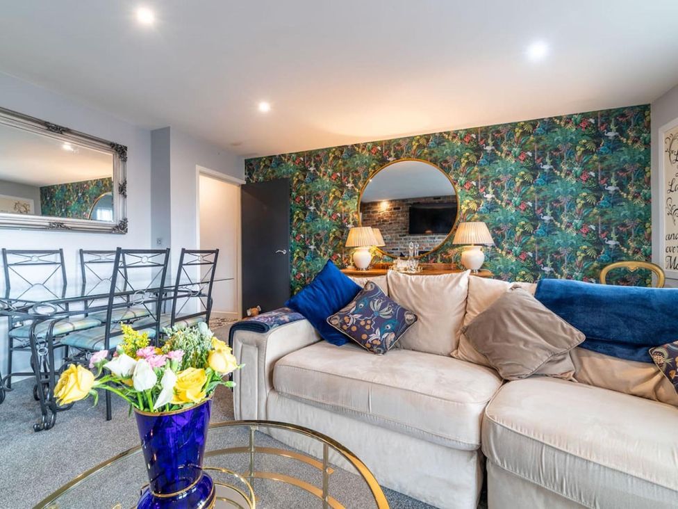 A living room with a sofa and dining area at the property