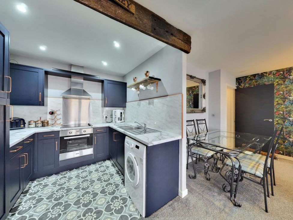 A kitchen with appliances and a dining table at The Old Barn in Manchester