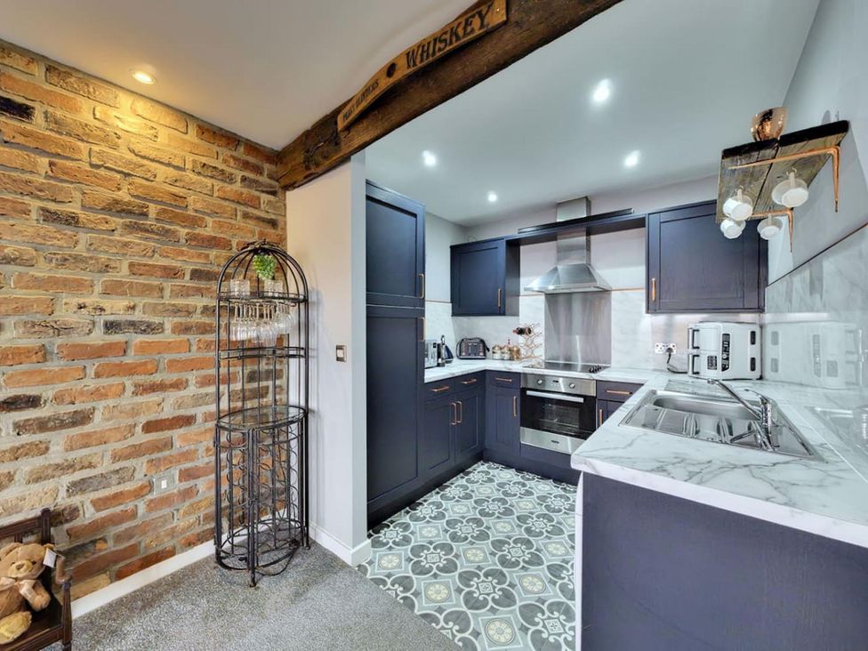 A kitchen with cabinets and appliances at The Old Barn in Manchester