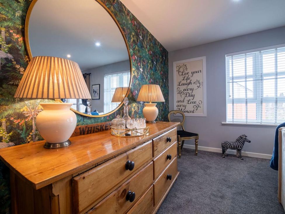 A living room with a mirror and lamp on a chest of drawers at The Old Barn in Manchester