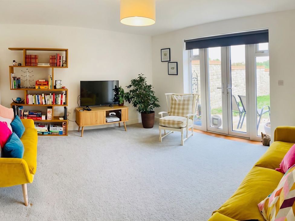 A living room with a television and bookshelf at the property location