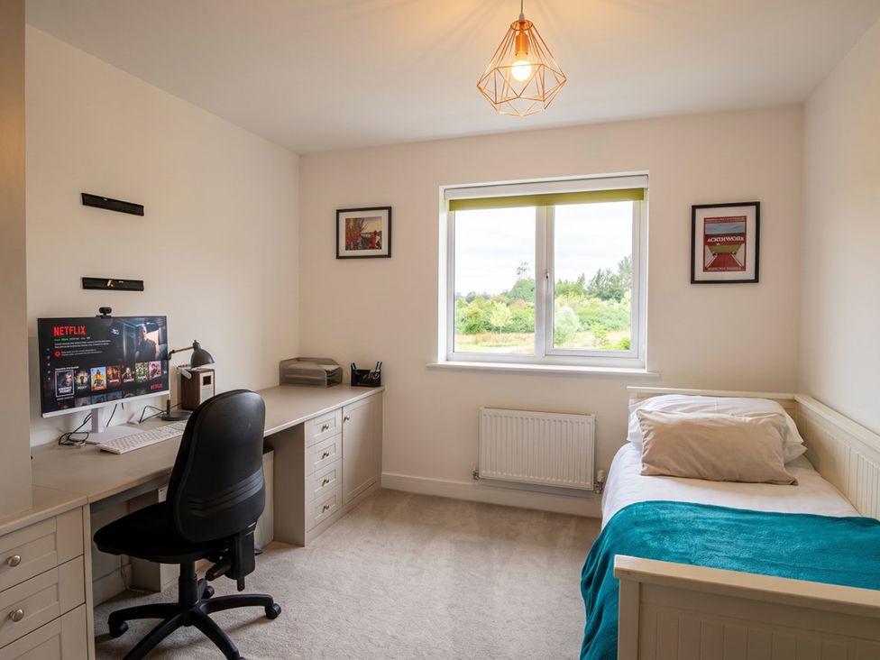 A bedroom with a computer desk and a bed at The Old Barn in Manchester