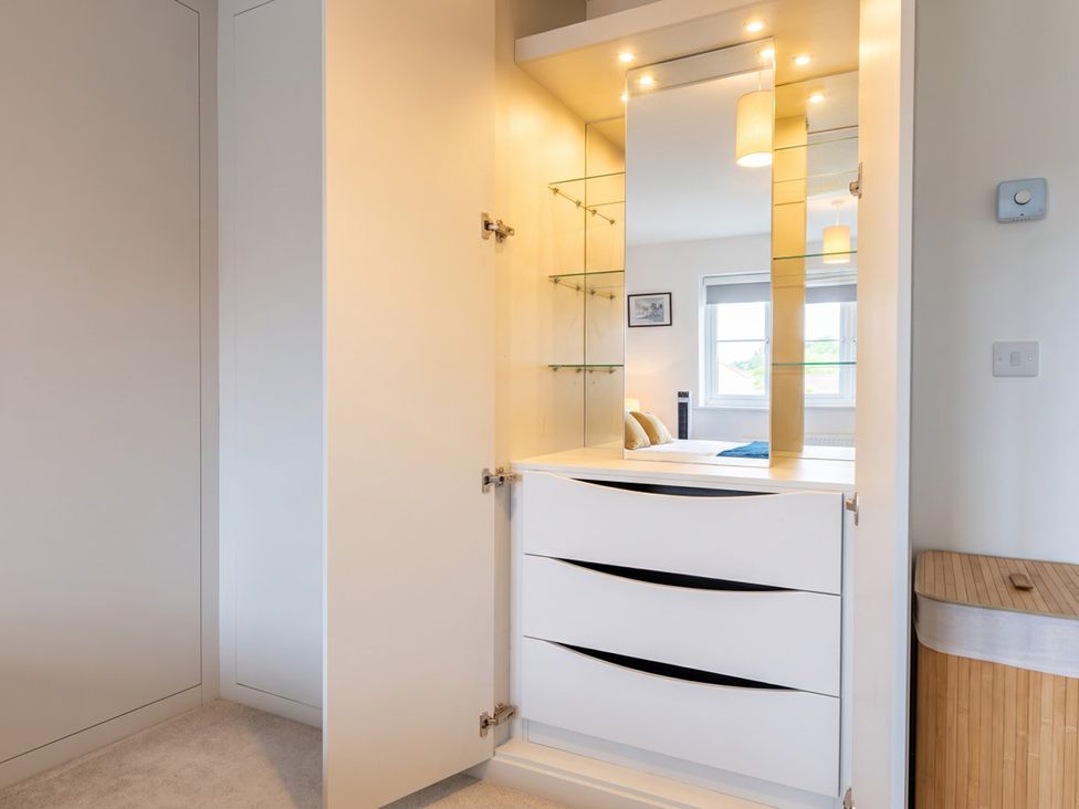 A wardrobe with mirror and shelves in a bedroom