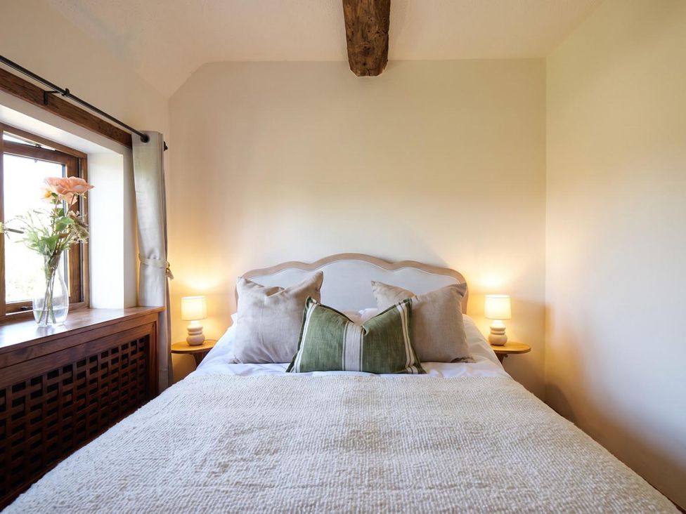 A bedroom with a bed and flower vase at 