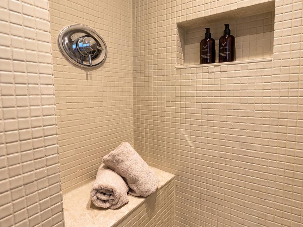 A shower with towels and soap dispensers at the property in the location