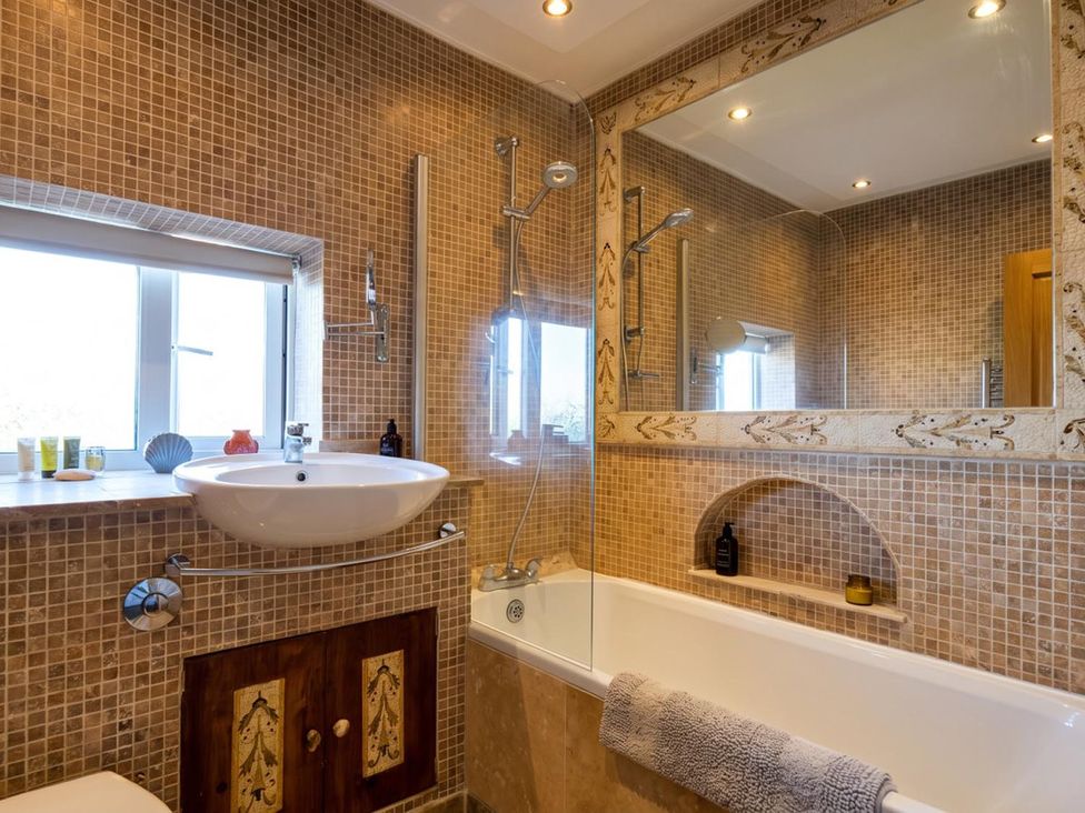 A bathroom with a bathtub and sink at The Old Barn in Manchester
