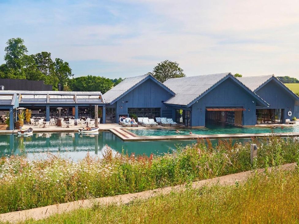 A building with a pool and sun loungers at a property in an outdoor area