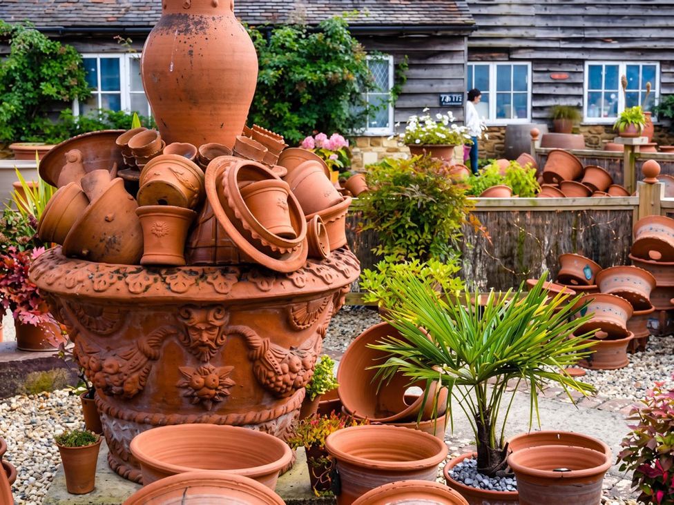 A garden with stacked terracotta pots and plants at 