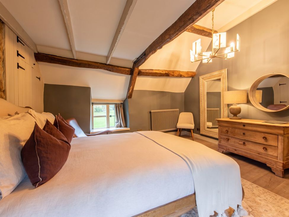 A bedroom with a bed and a mirror at The Old Barn in Manchester
