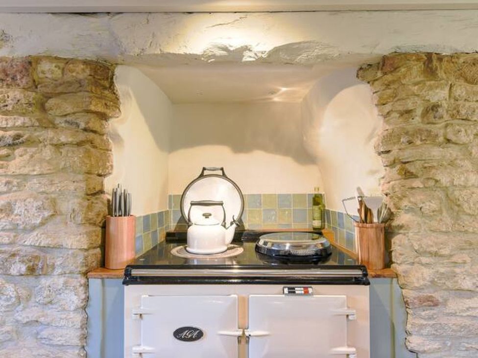 A kitchen with an oven, kettle, and utensils at The Old Barn in Manchester