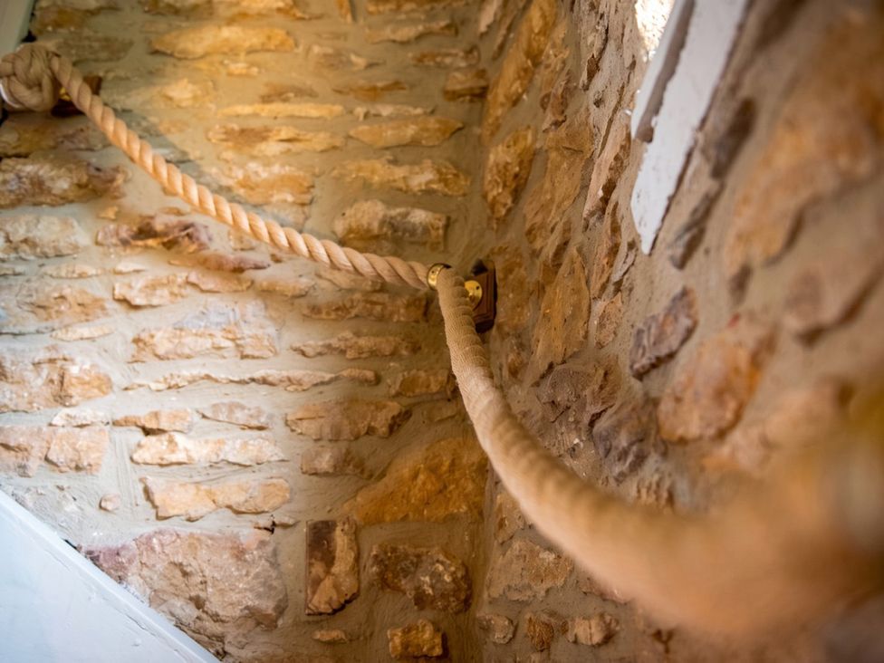 A rope fixed to a stone wall in a staircase