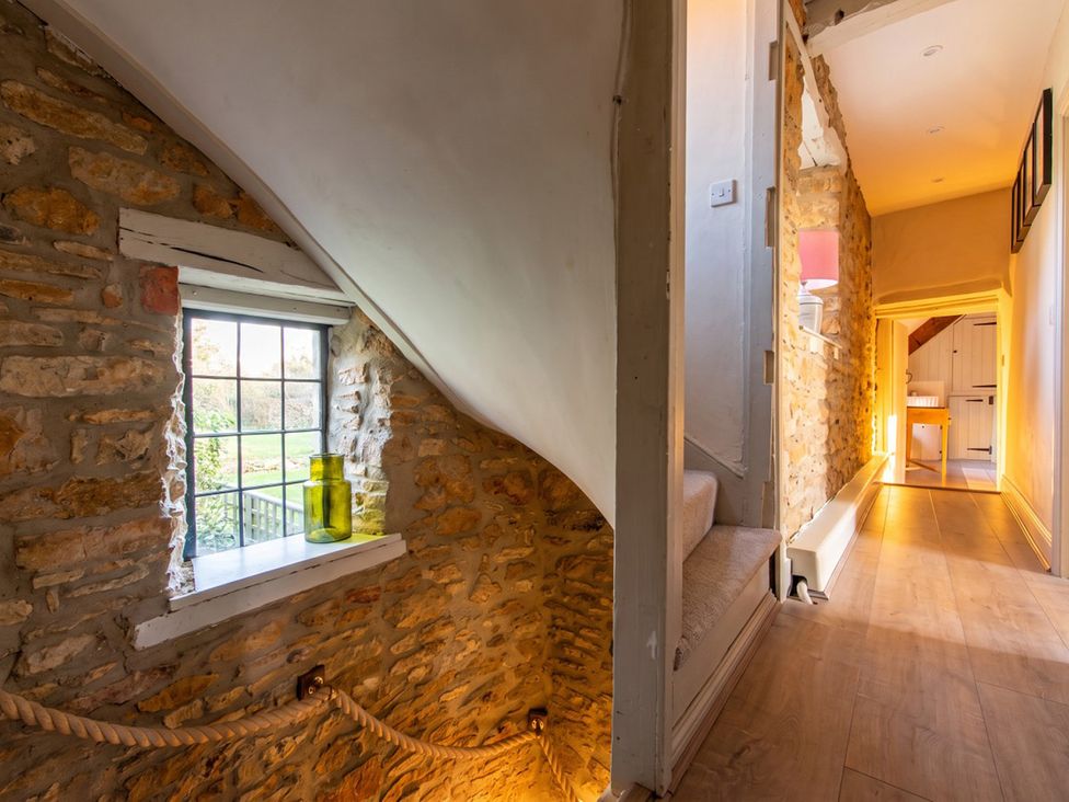 A hallway with a stone wall and a window at 