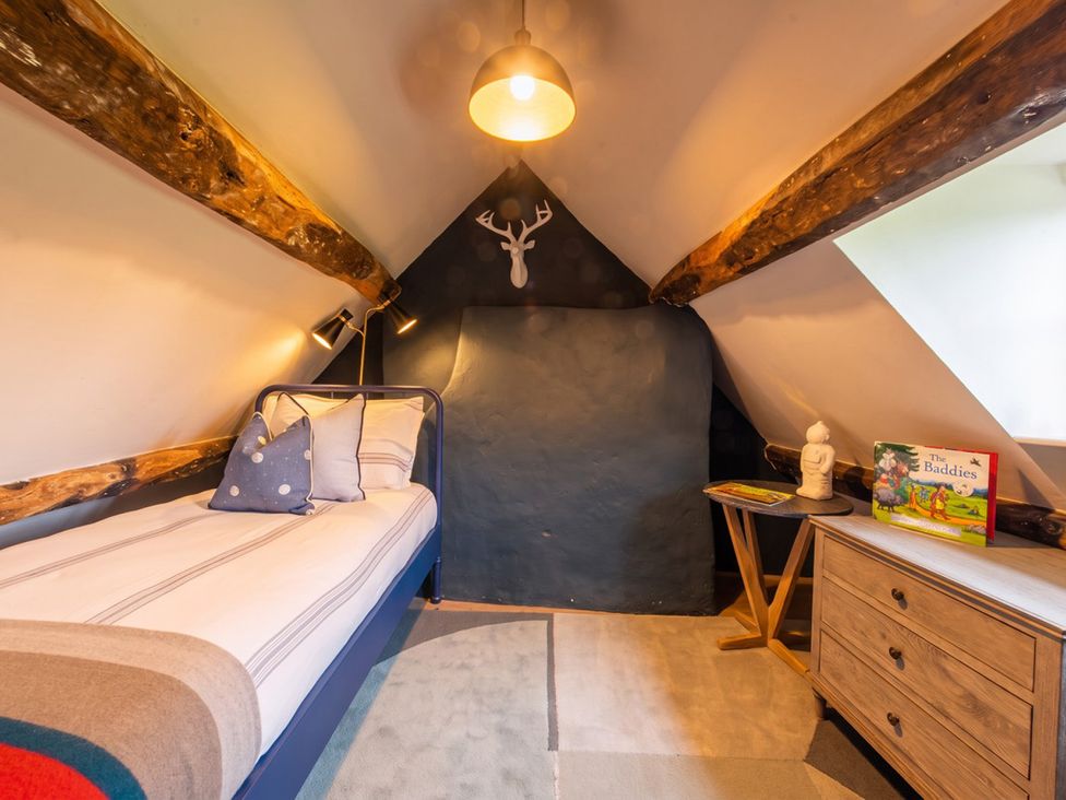 A bedroom with a bed and bookshelf at The Old Barn in Manchester