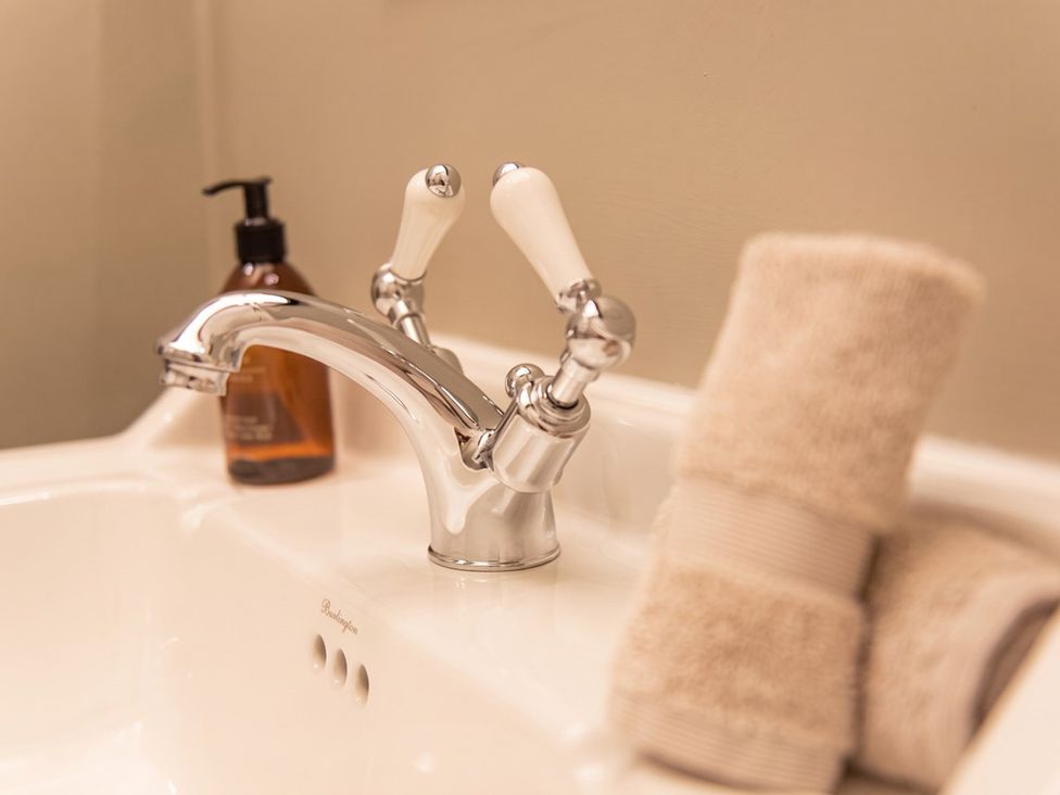 A sink with a faucet and towels at the bathroom