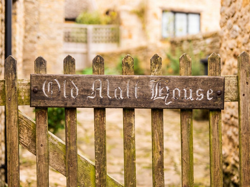 A wooden gate with a sign at Old Malt House