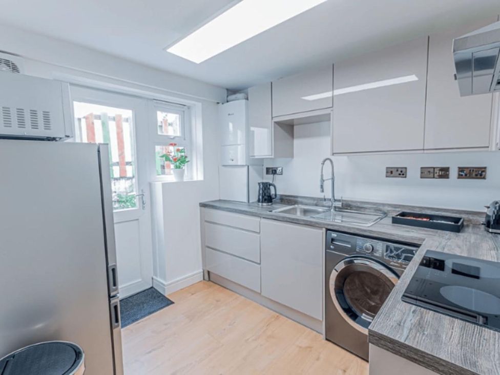 A kitchen with appliances and work surfaces in a modern design at The Old Barn in Manchester