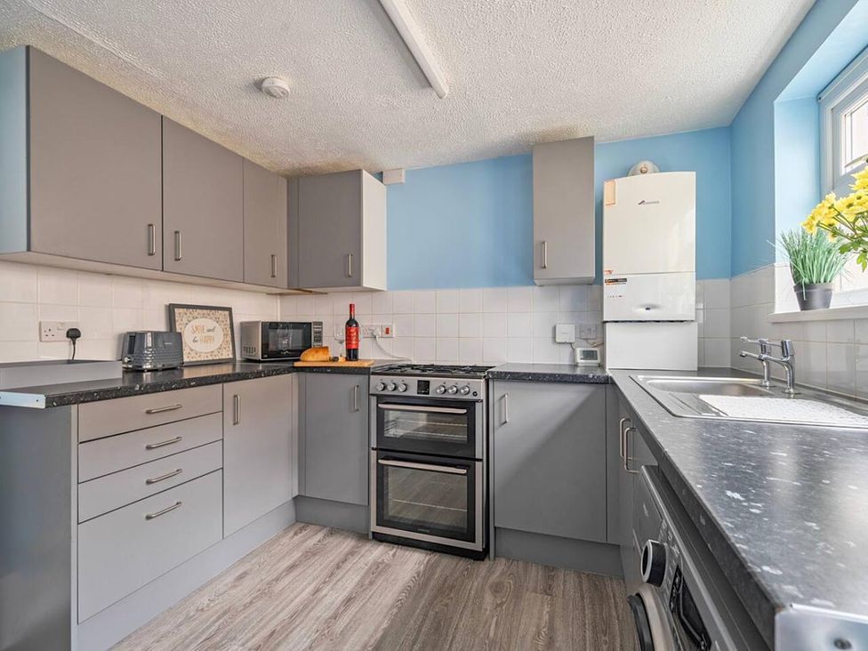 A kitchen with cabinets, oven, sink, and appliances at The Old Barn in Manchester