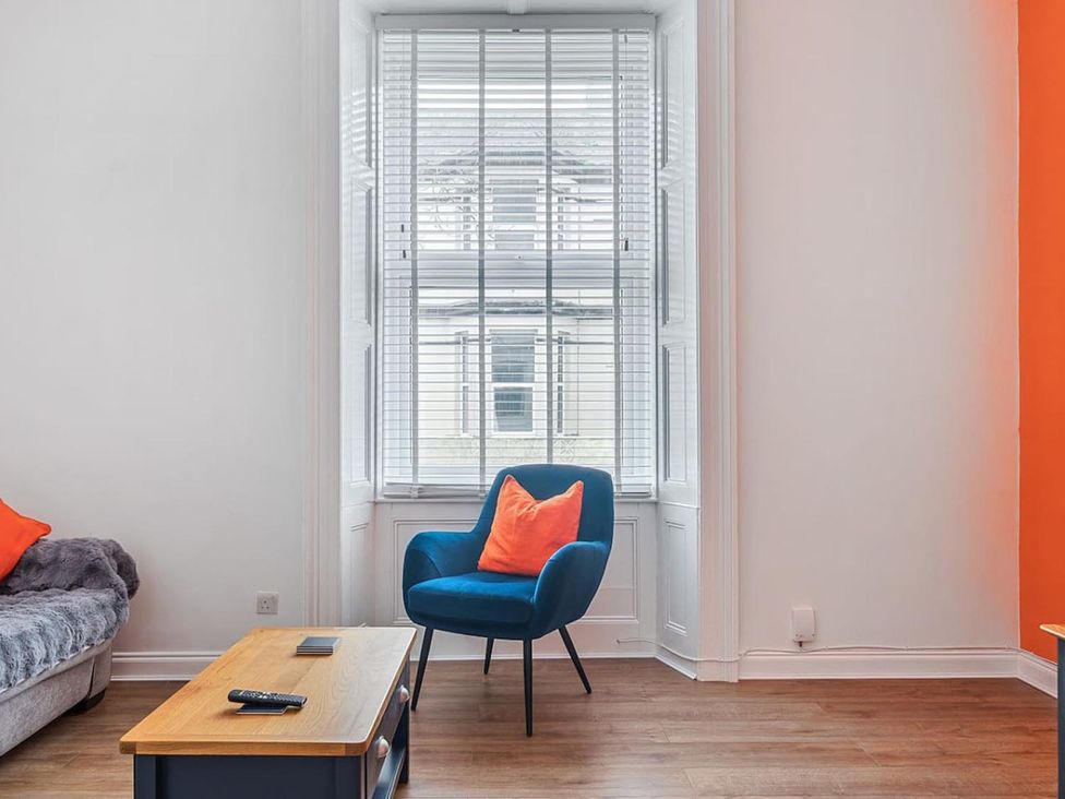 A living room with a blue chair and coffee table at the property in location