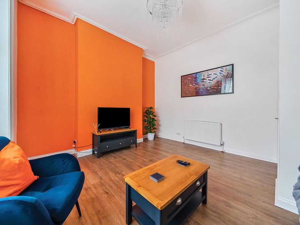 A living room with a sofa, television, and coffee table