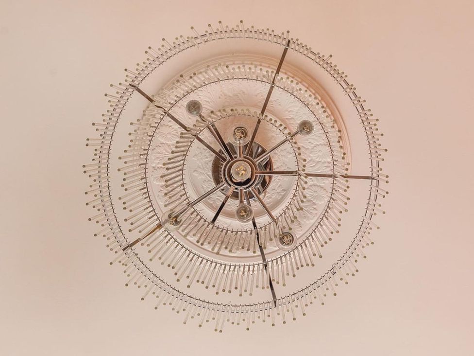 A chandelier with multiple light bulbs and decorative ceiling medallion