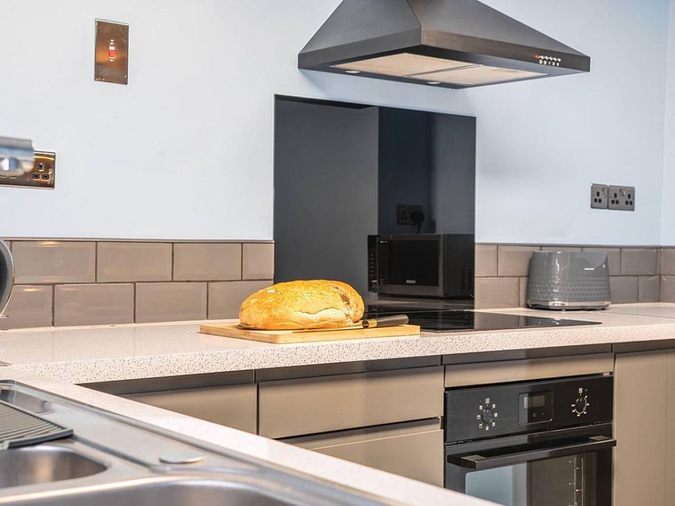 A kitchen with a loaf of bread on a cutting board at the property in 