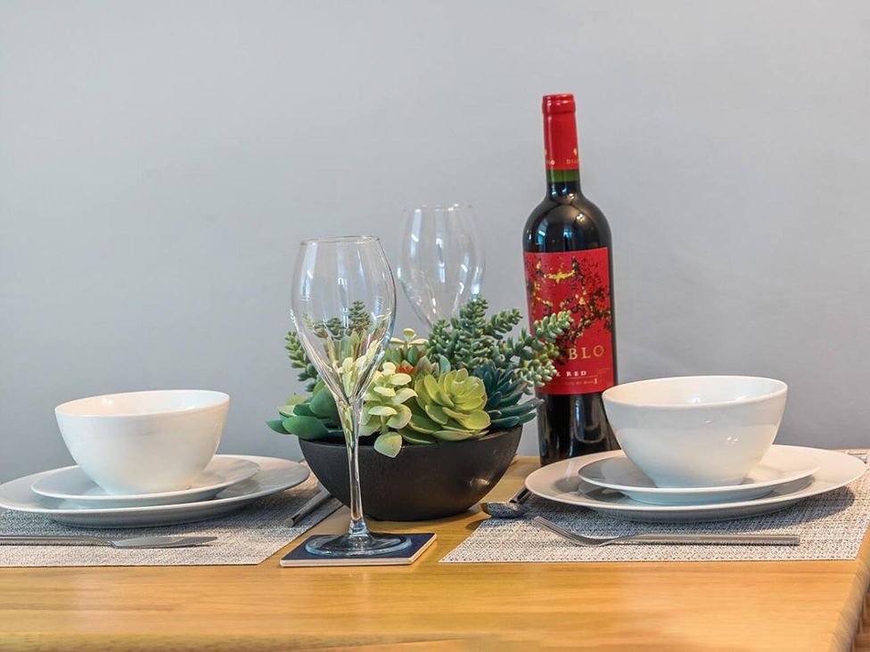 A dining table set with plates and wine glasses at the property in the location