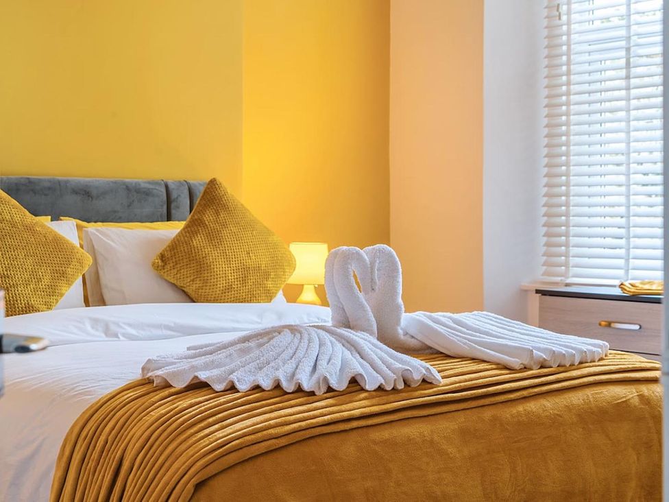 A bedroom with a bed and towels arranged on the bed at The Old Barn in Manchester