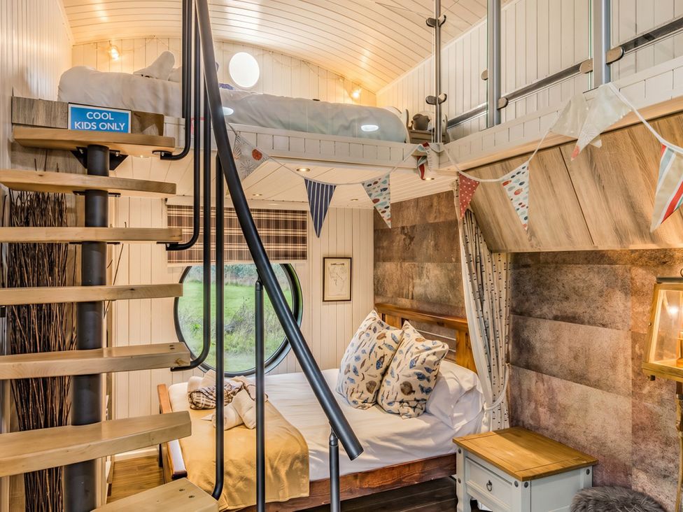 A bedroom with a bunk bed and spiral staircase at the property in unspecified location