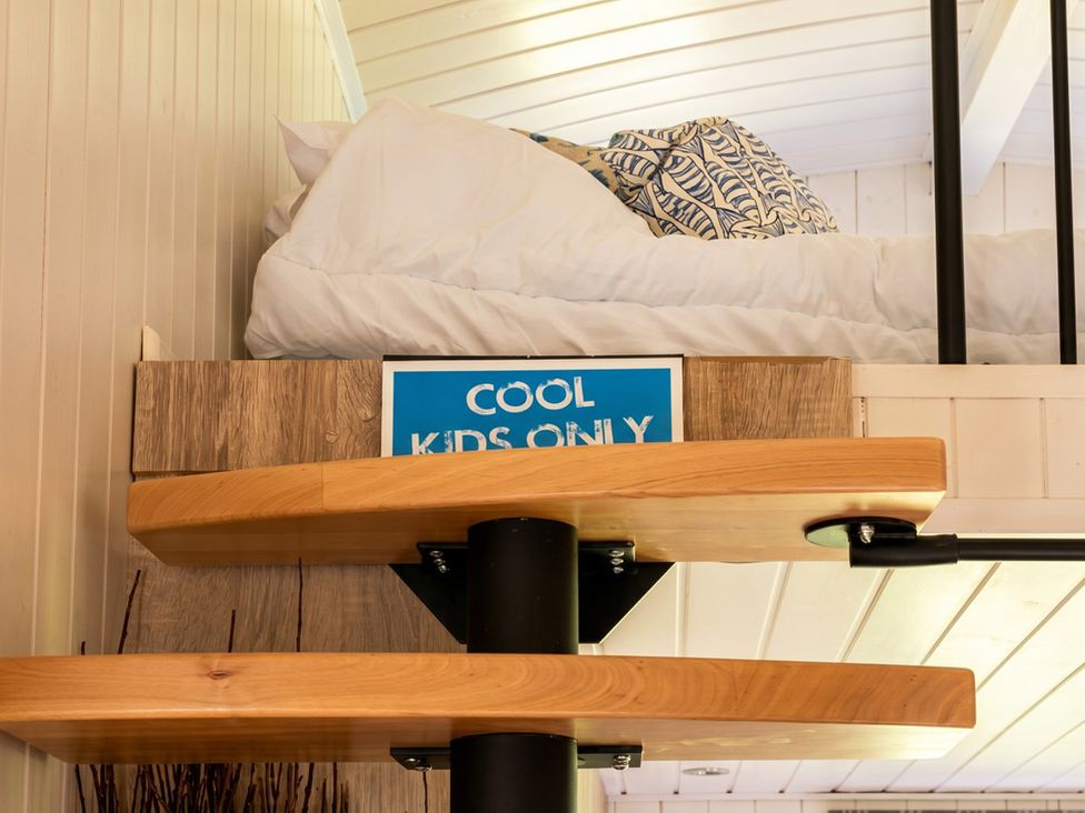A bedroom with a bed and a sign saying COOL KIDS ONLY